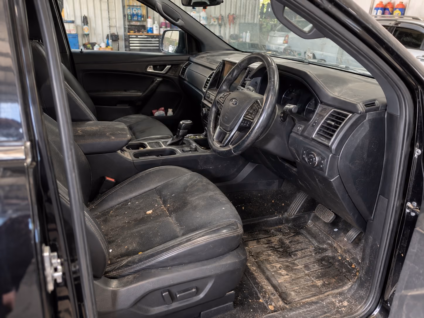 A car interior before detailing, showing dirt and staining