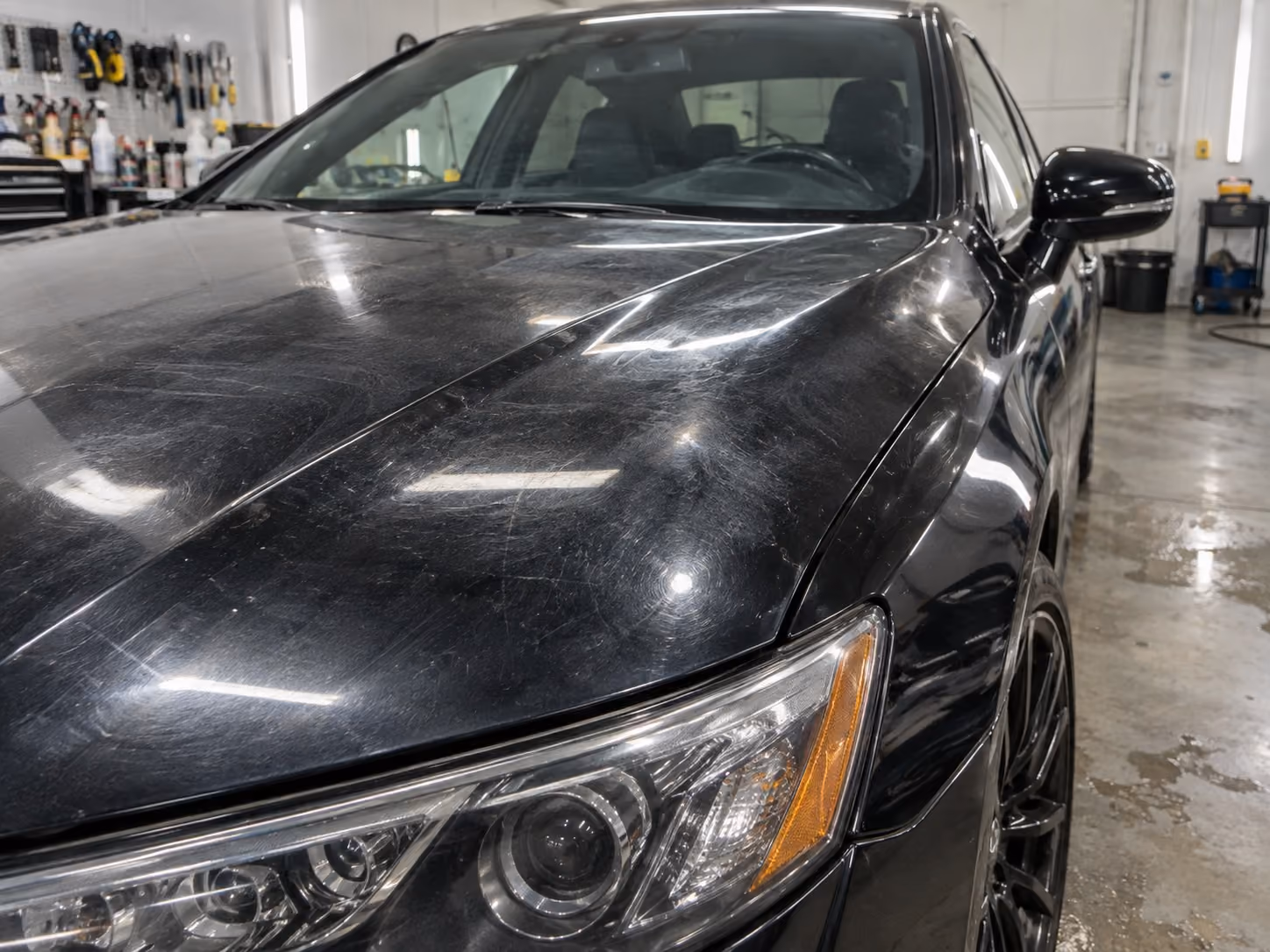Car paint showing swirl marks and light scratching before correction