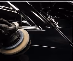 A machine polisher being used on a car panel during paint correction